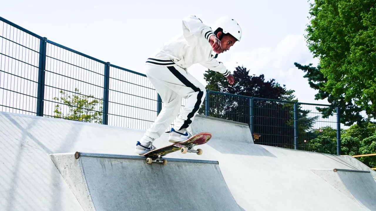 A young boy skateboarding in a skatepark.