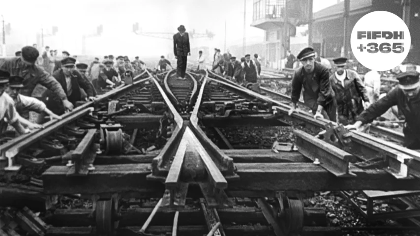 Des hommes travaillant sur des voies ferrées dans une ancienne photographie en noir et blanc.